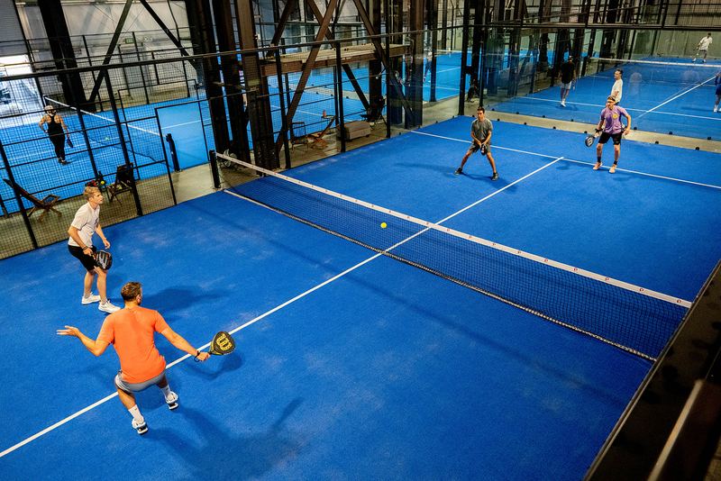 Play underway on adjacent courts inside the converted warehouse