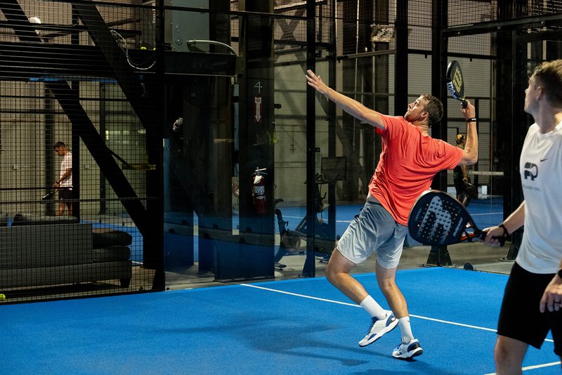A player leaves the ground to attack a high ball at Foundry Padel