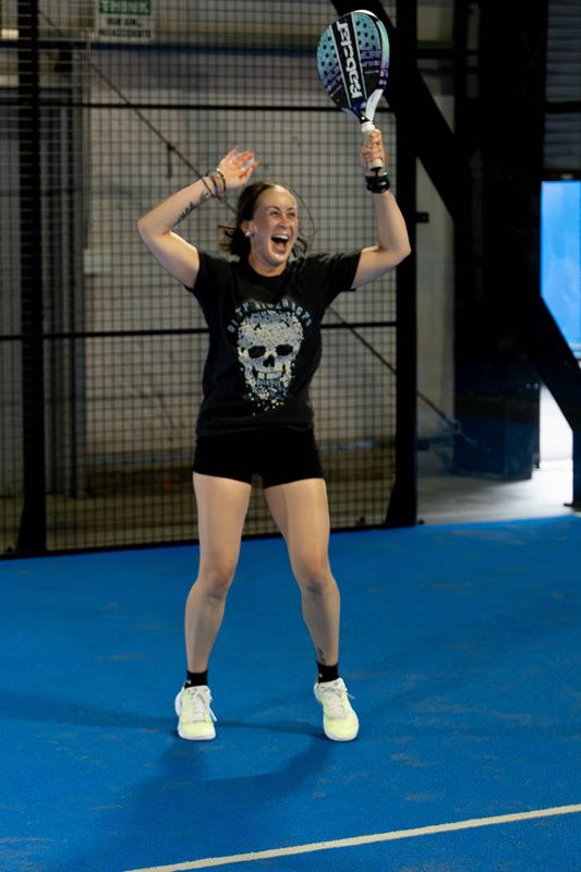 A player throws her arms up after winning the point