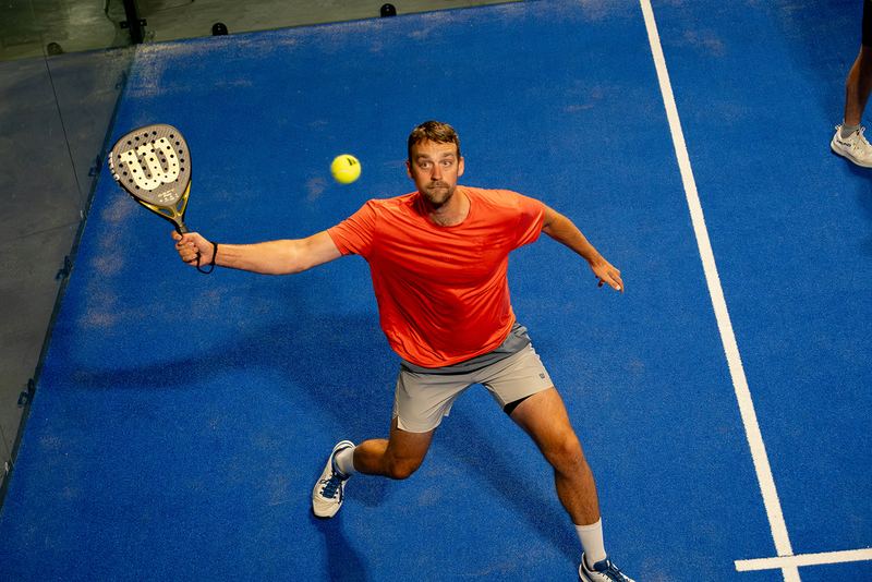 A player makes contact on a forehand, ball frozen at the paddle