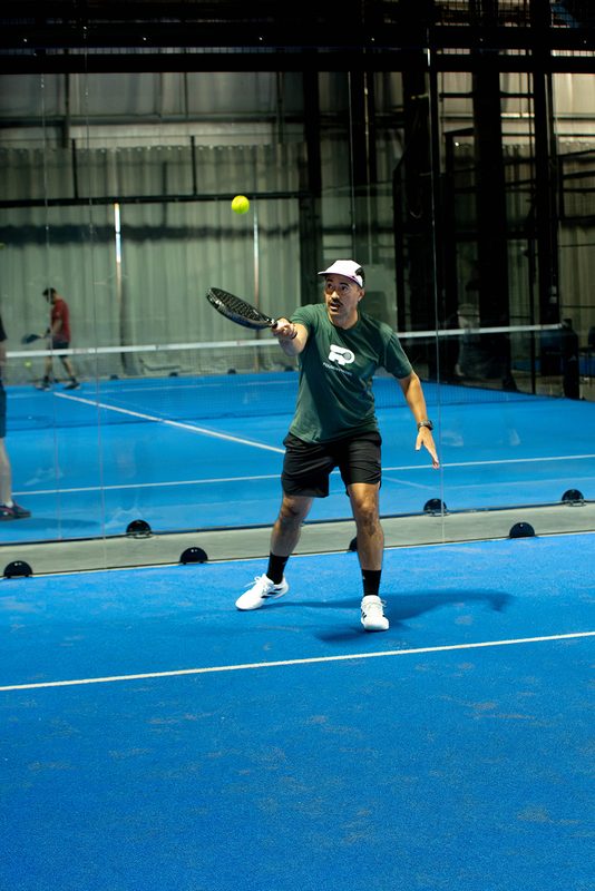 A player drives a forehand down the line past the net at Foundry Padel
