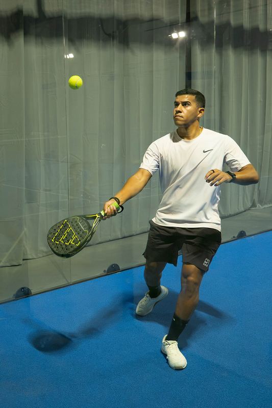 A player drives a forehand from mid-court