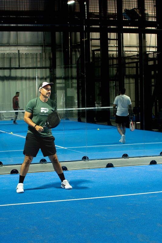 A member in a Foundry Padel tee waits for the serve on court