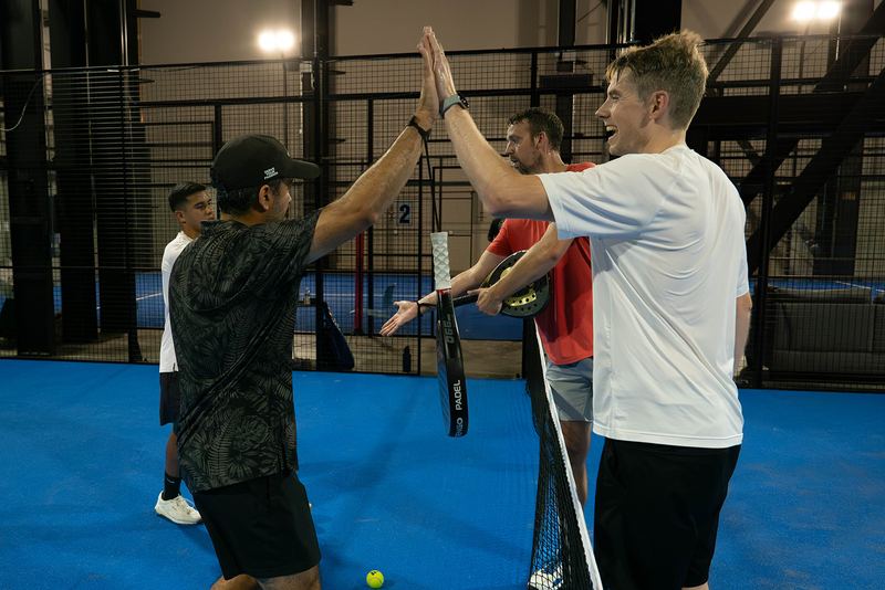 Players high-five at the net after a league match