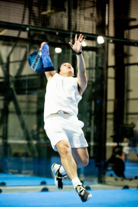 A player leaves the ground for an overhead smash