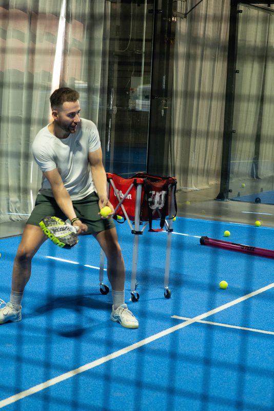 A player drops into a low ready position during a drill at Foundry Padel
