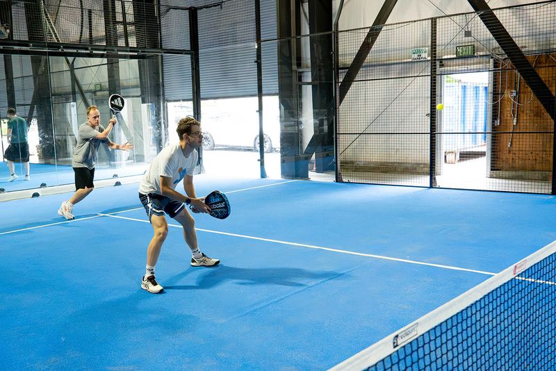 Daylight through the open rollup door at Foundry Padel