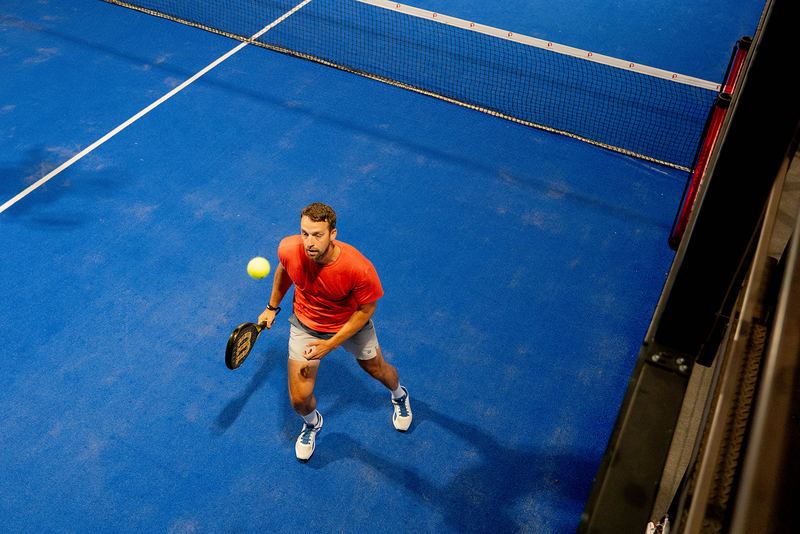 An overhead view of a player tracking the ball across the blue court