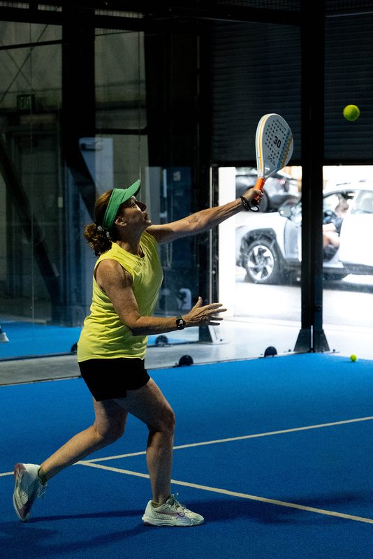 A player stretches up for an overhead with daylight behind them at Foundry Padel
