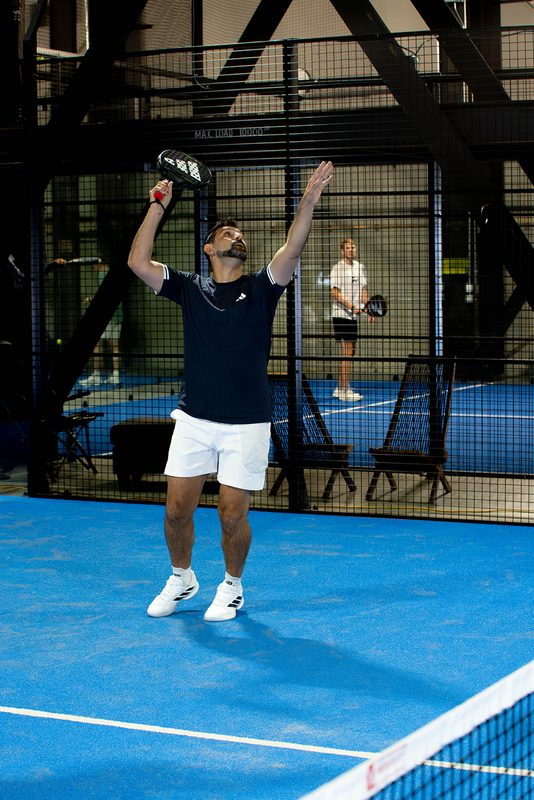 A player throws both arms up after taking the point at Foundry Padel