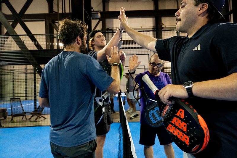 Players gather at the net to trade high-fives after a match