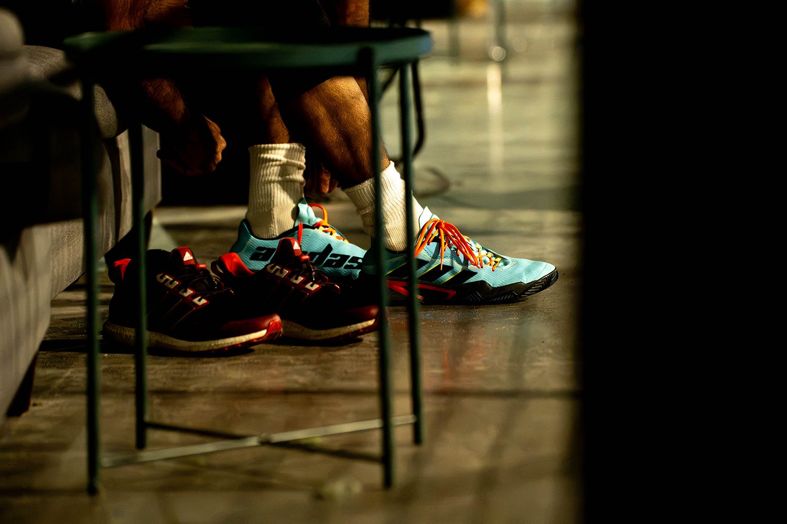 Padel shoes tucked under a lounge table between matches at Foundry Padel